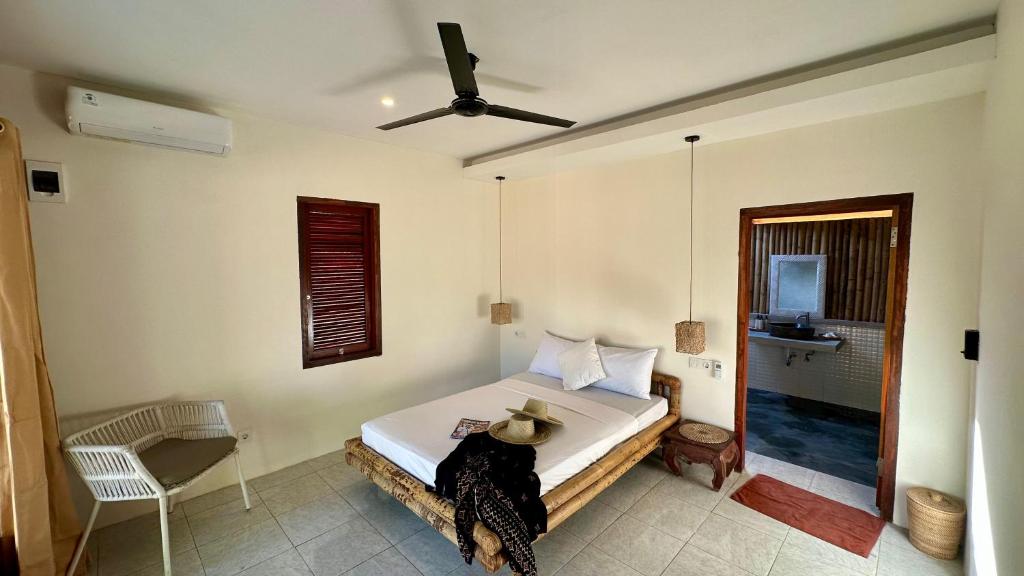 Un dormitorio con una cama con un sombrero encima. en Lagoona Resort Gili Gede, en Gili Gede