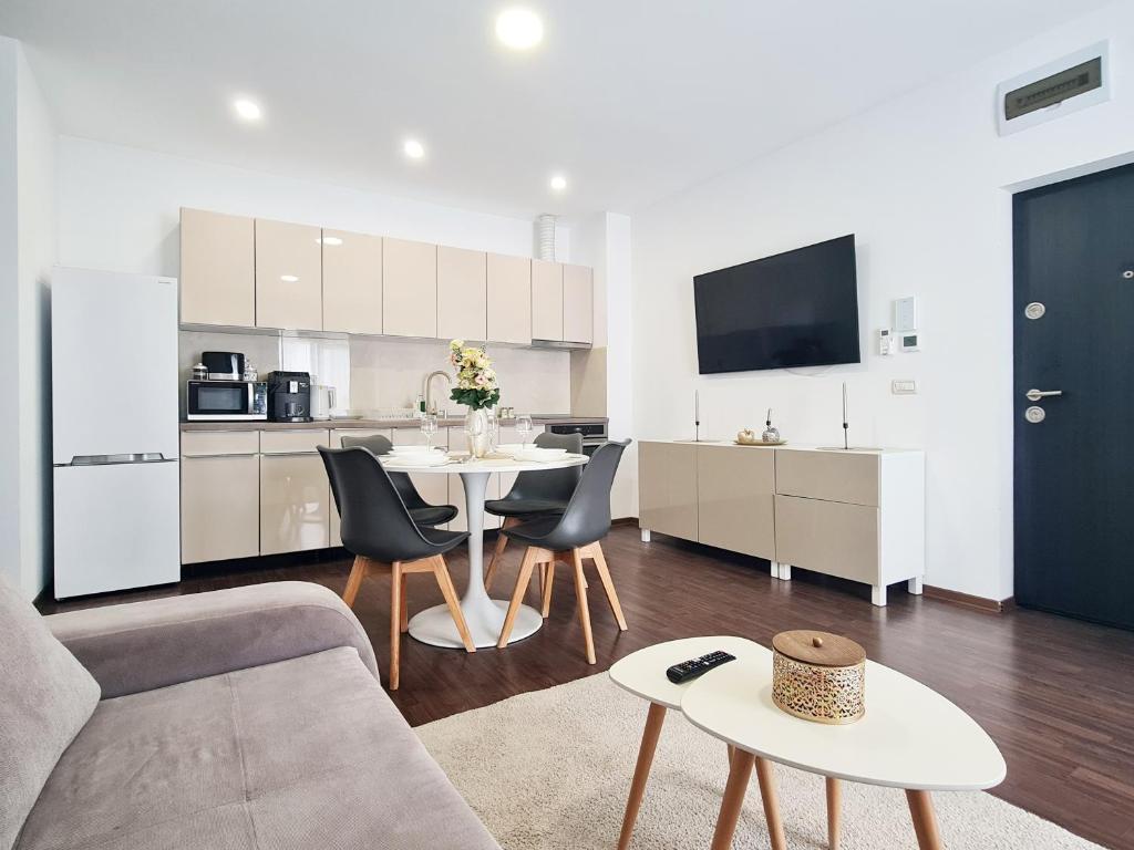a living room with a table and a kitchen at Esther Line Apartments - self check-in, free private parking in Timişoara