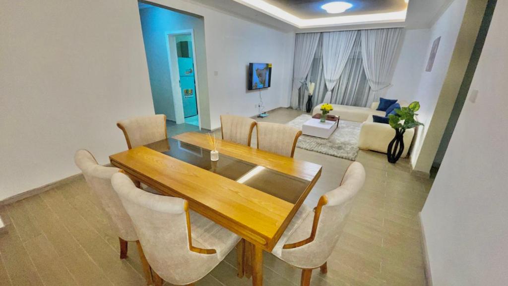 Un comedor con mesa y sillas de madera. en Mimo Apartment, en Addis Ababa