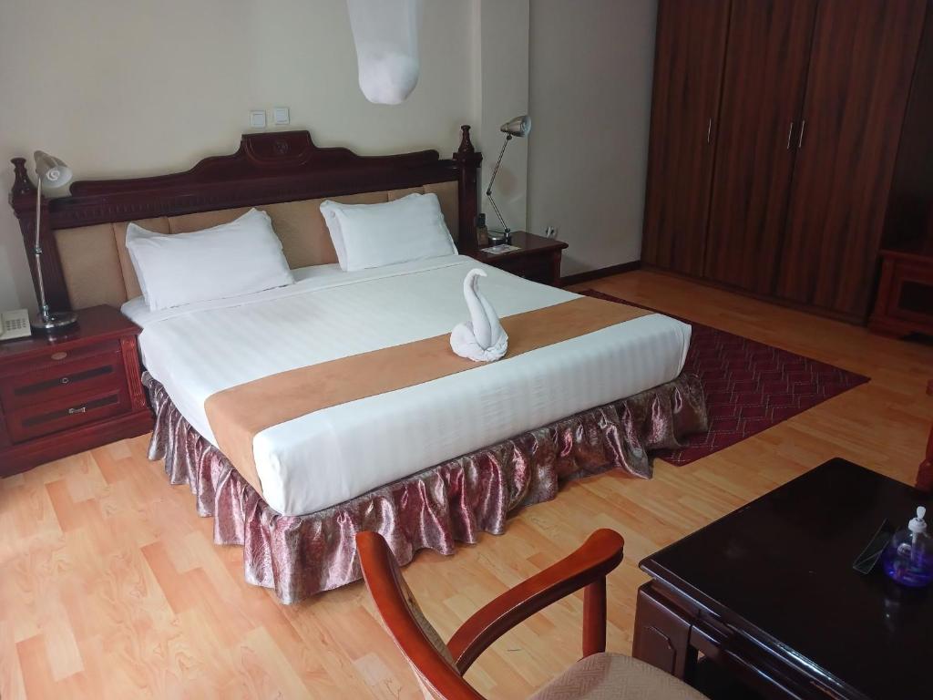 Nazrethkereyu hill resort hotel的一间卧室配有一张大床,上面有天鹅