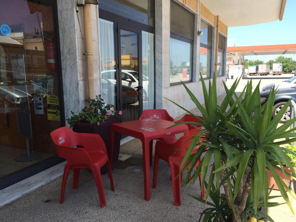 コラートにあるHotel Zio Cataldoの赤いテーブルと椅子
