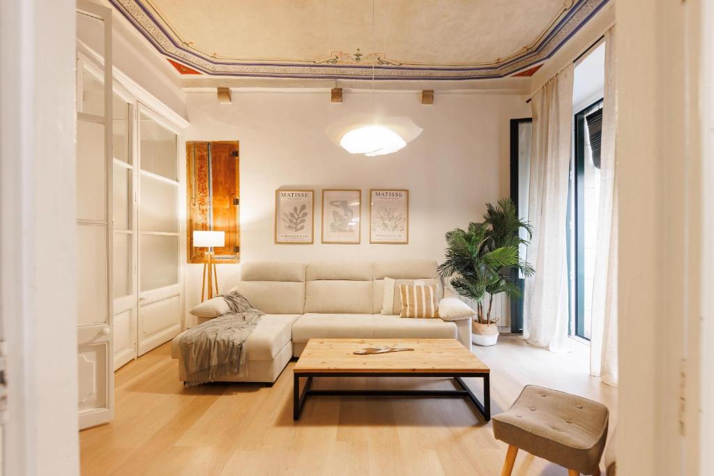 a living room with a couch and a table at Bravissimo Plaça del Vi, Authentic Historic Apartment in Girona