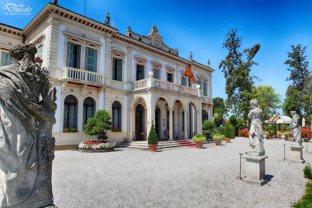 duży dom z posągami przed nim w obiekcie Villa Ducale Hotel & Ristorante w mieście Dolo
