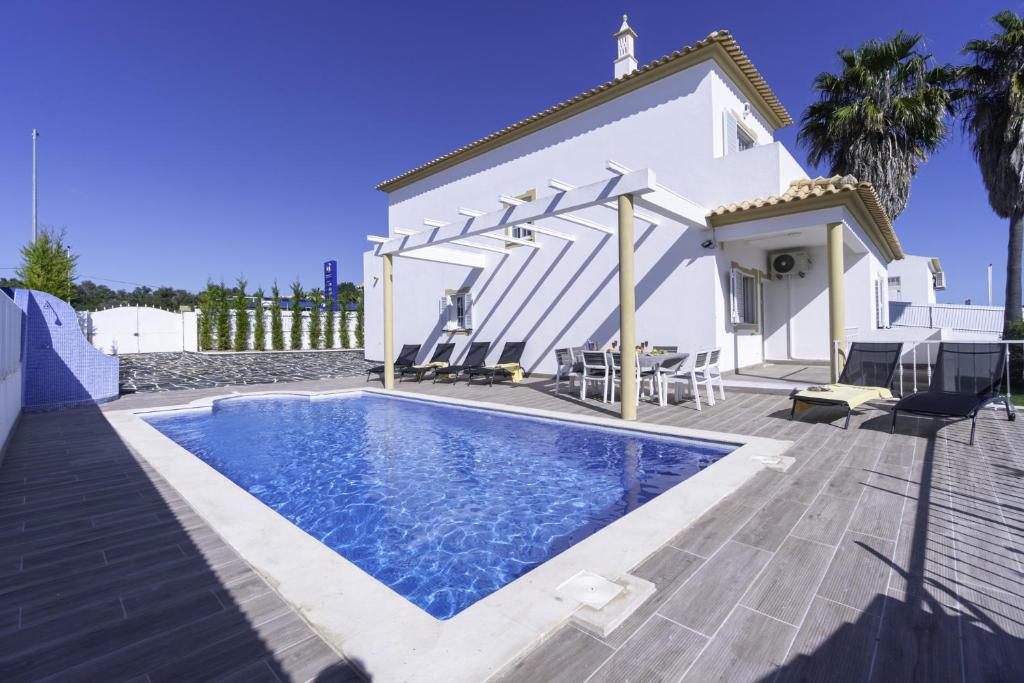 a swimming pool in front of a white house at Villa Menina by Ocvillas in Albufeira