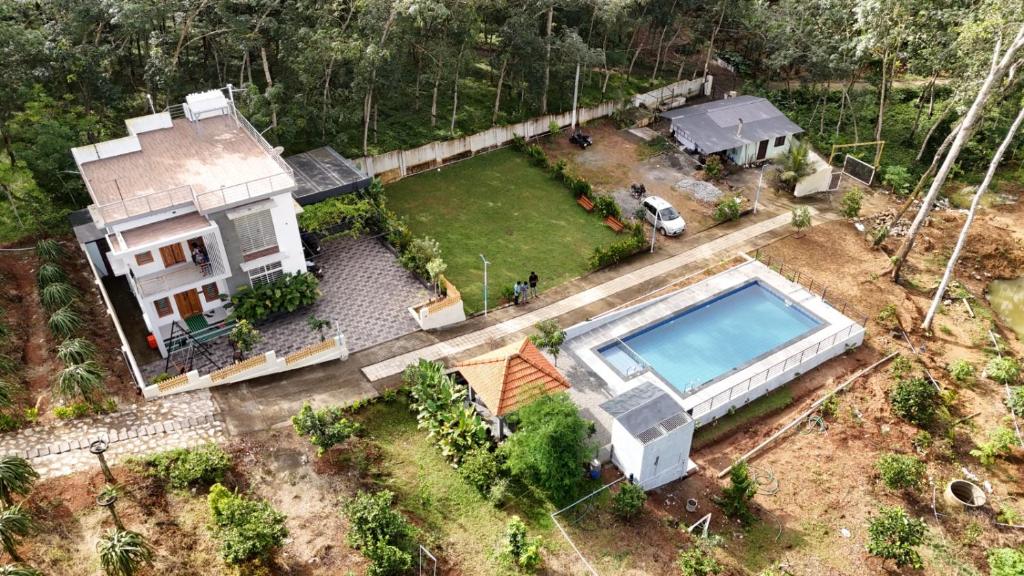 an aerial view of a house with a swimming pool at Bk farmhouse homestay in Bālarāmpuram