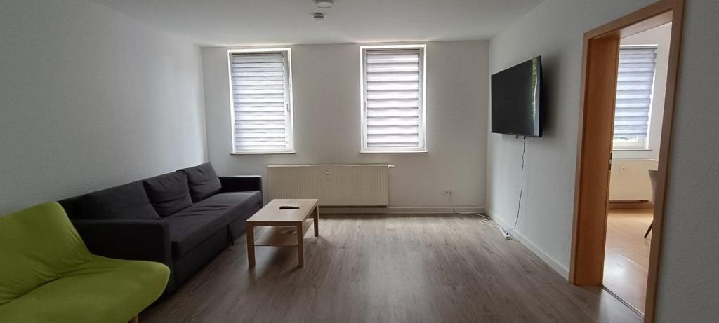 een woonkamer met een bank en een tafel bij Ferienwohnung Roko in Eisenach