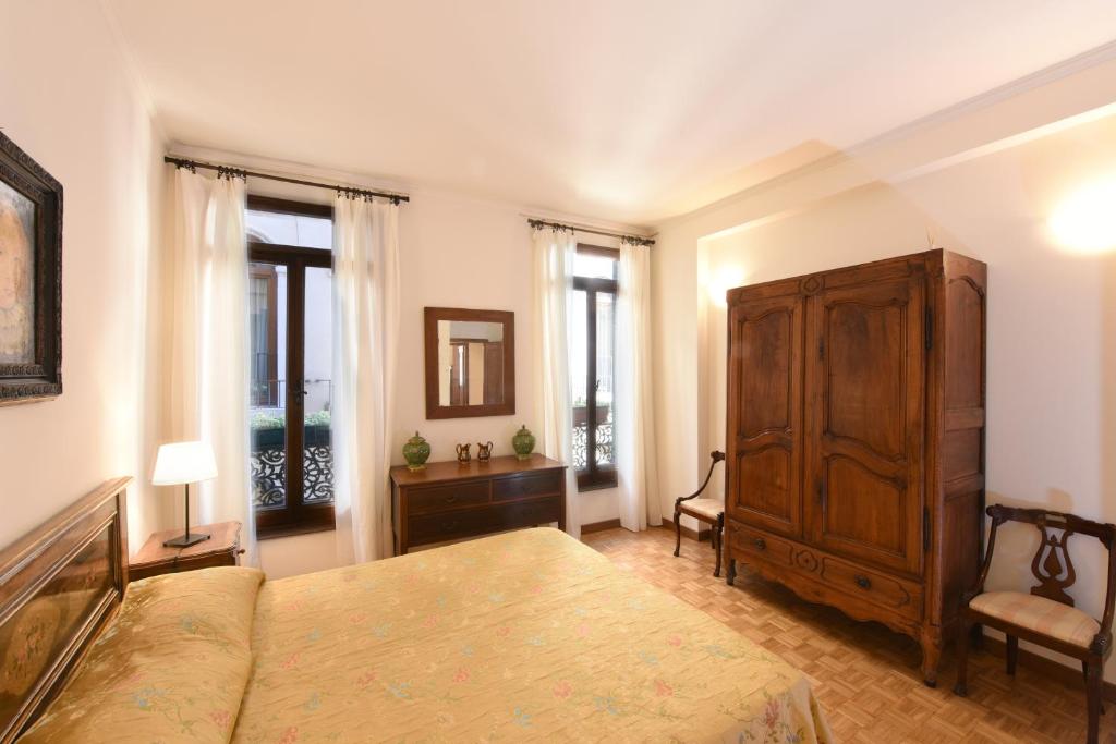ヴェネツィアにあるLe Due Corone Bed & Breakfastのベッドルーム1室(ベッド1台、キャビネット、窓付)