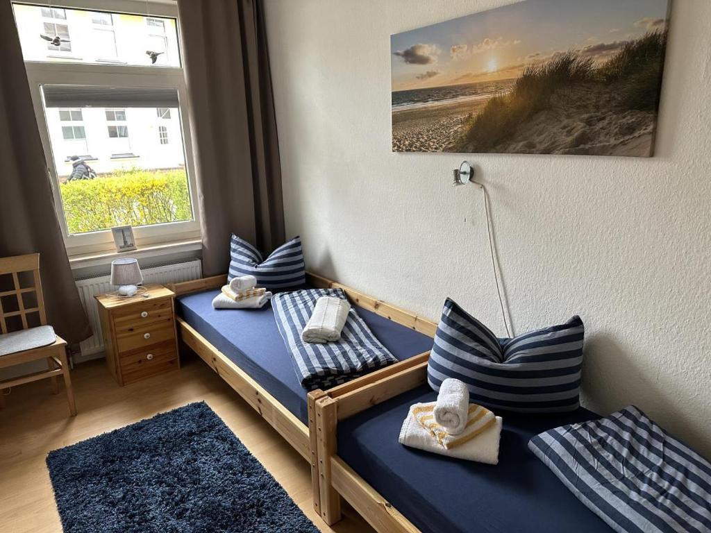 two twin beds in a room with a window at Leuchtturmblick in Borkum