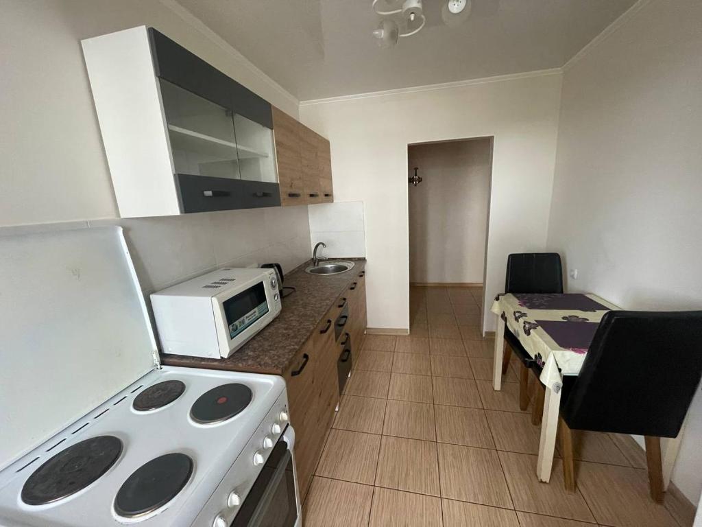 a kitchen with a stove and a microwave at Проста і затишна квартира! Бульвар Шевченко in Cherkasy