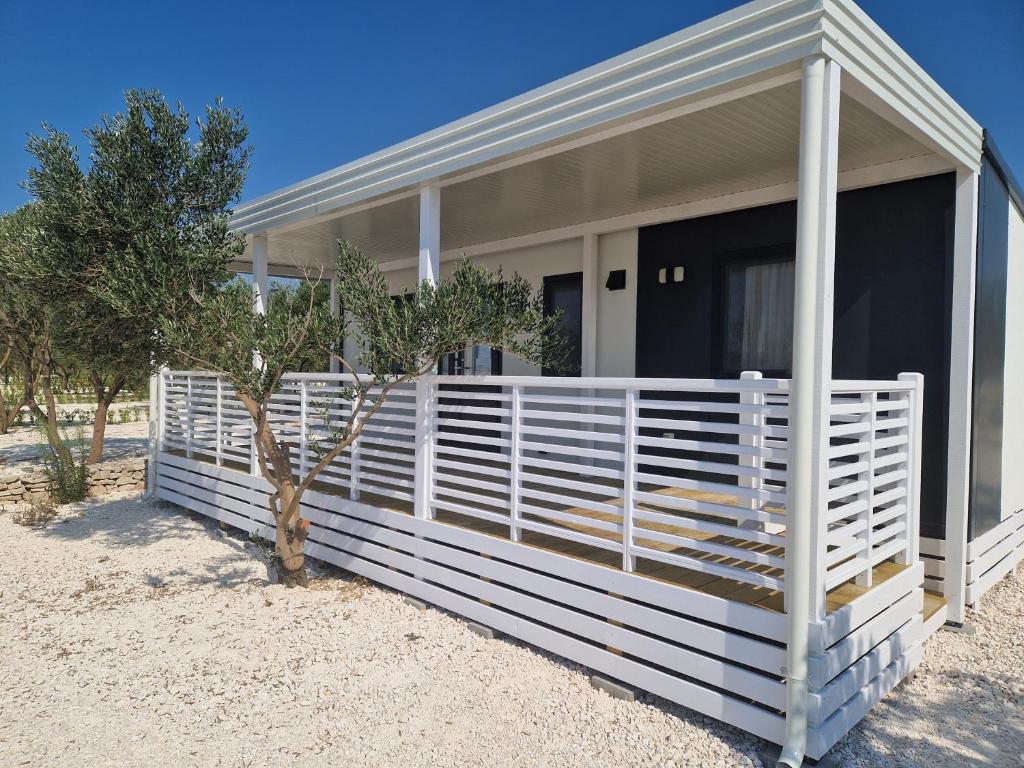 a white fence in front of a house at Camping Resort Šibenik in Razvala