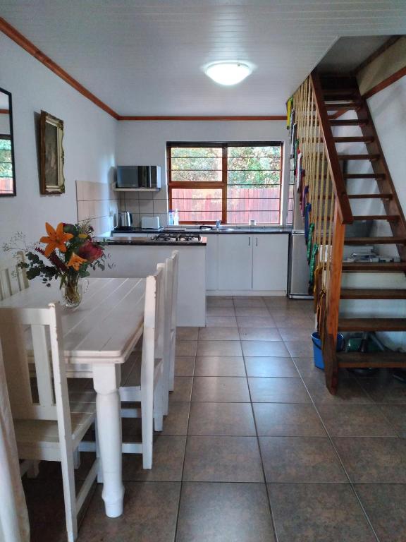 a kitchen with a table and a kitchen with a staircase at Bush Beach Safari Accommodation in Jeffreys Bay