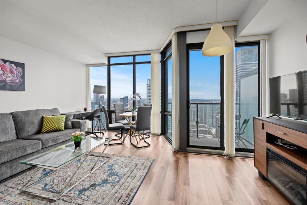 ein Wohnzimmer mit einer Couch und einem Glastisch in der Unterkunft Attractive 1 Bedroom High Floor with Skyline View in Toronto