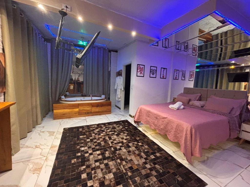 Un dormitorio con una cama y un baño con bañera. en Suite Piscina térmica e Banheira Jacuzzi a 20km de Ctba, en Campina Grande do Sul
