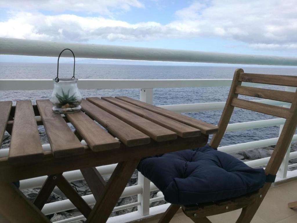 a picnic table with a lamp on a balcony overlooking the ocean at Loft en Callao Salvaje con Piscina y Vistas al Mar in Callao Salvaje