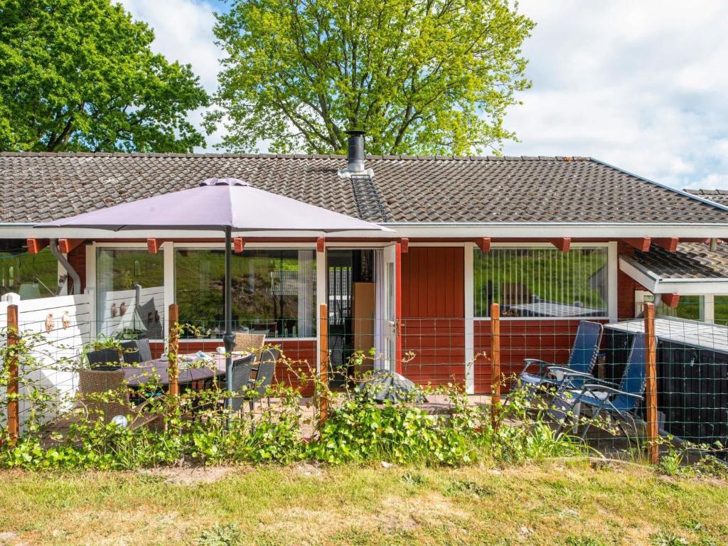 a house with a screened in porch with a fence at 4 person holiday home in Aabenraa in Aabenraa