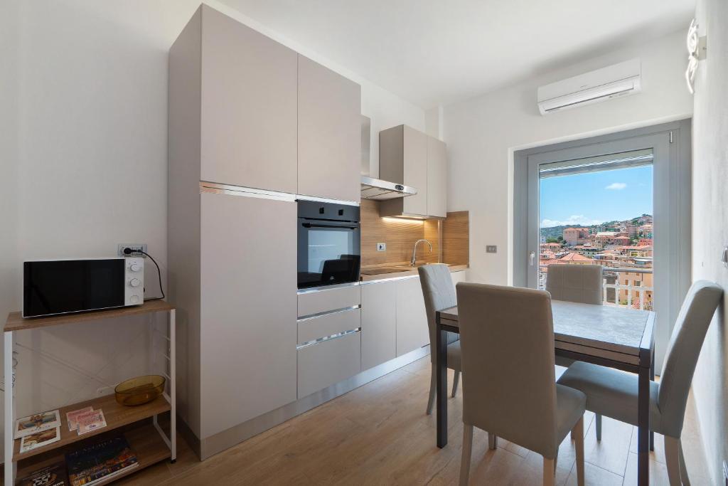 une cuisine et une salle à manger avec une table et une fenêtre dans l'établissement Casa A Prima Vista Varazze, à Varazze