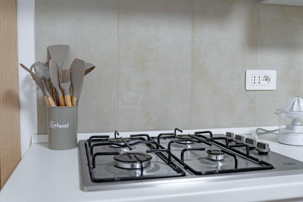 a stove top oven with a container of utensils at A casa dei nonni in Scala