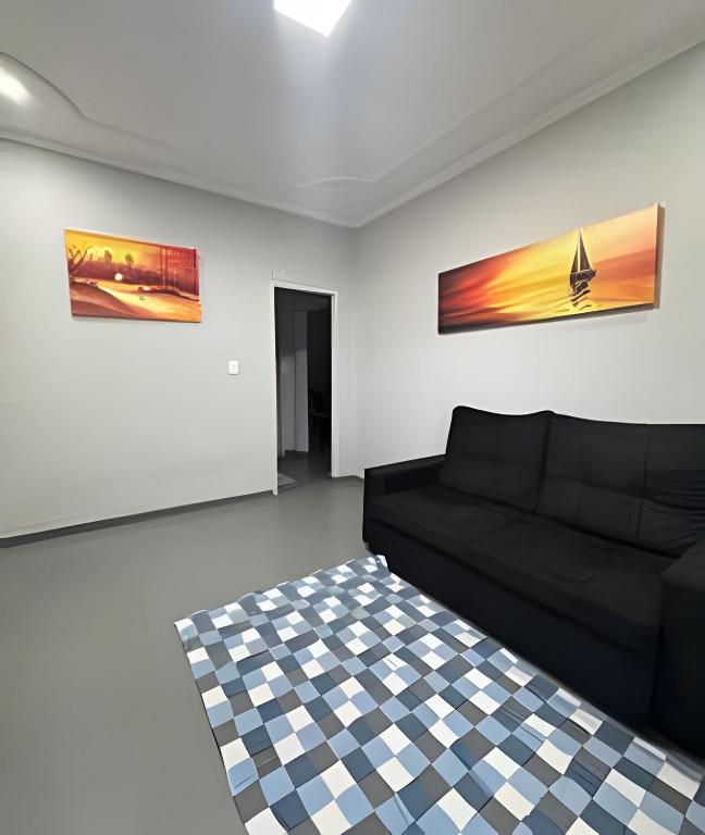 a living room with a couch and two paintings on the wall at Casa Bairro Bosque com 3 quartos in Rio Branco