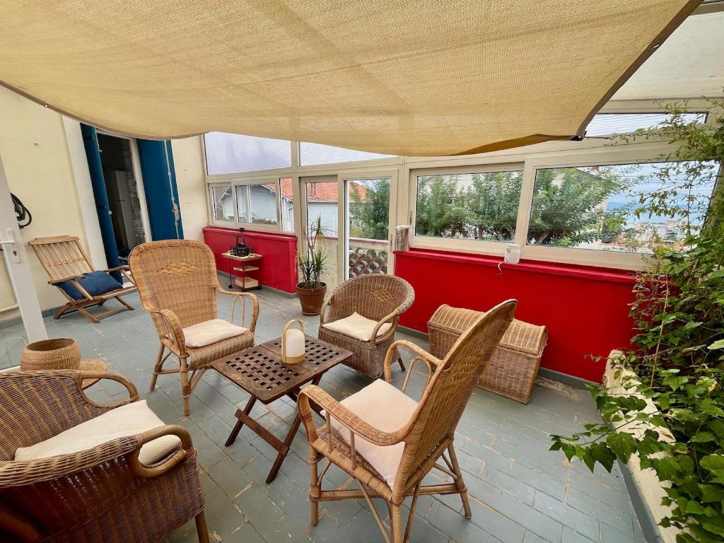 une terrasse avec des chaises en osier et une table avec une bougie dans l'établissement "La Liberté" Maison de ville, Parking, Wi-Fi, à Sète