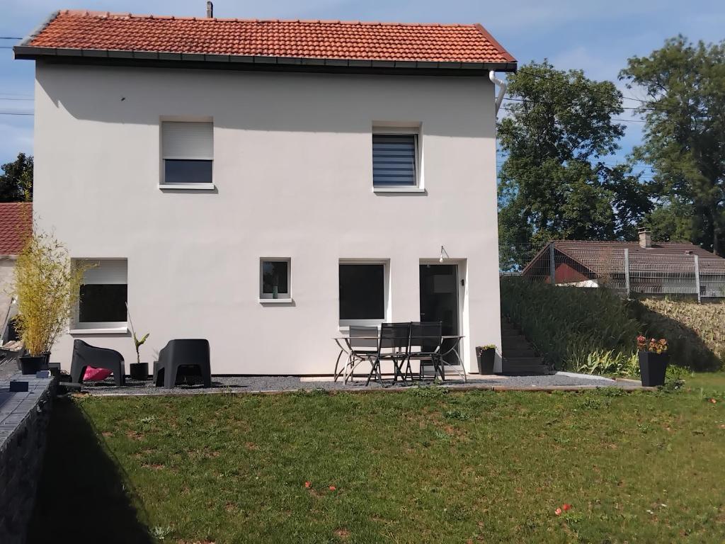 a white house with a picnic table in front of it at Kity House maison individuelle avec jardin in Neufchâteau