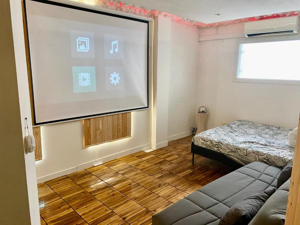eine Leinwand in einem Zimmer mit einem Bett in der Unterkunft Appartement au coeur de Béziers in Béziers