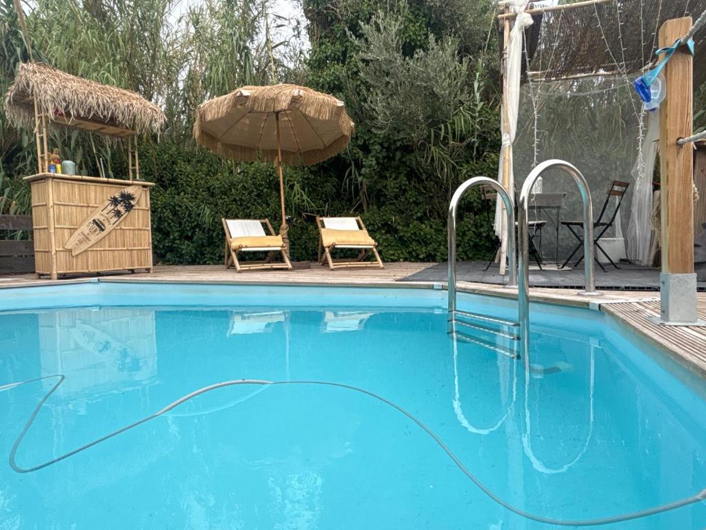 basen z parasolem i dwoma krzesłami w obiekcie La villa perla w Marsylii