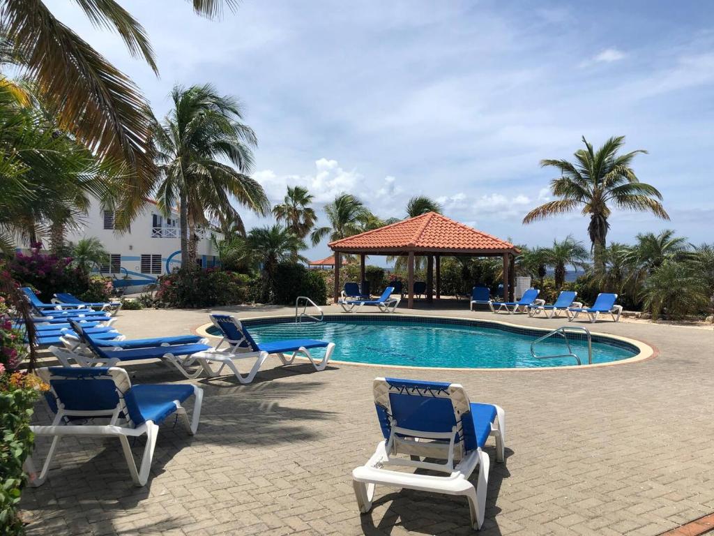 a swimming pool with lounge chairs and a gazebo at Little Slice of Paradise in Westpunt