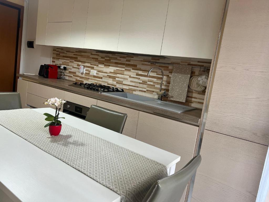a kitchen with a table with a vase of flowers on it at Mattei13 in Bologna
