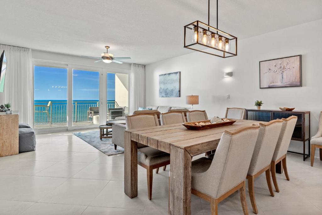 Un comedor y una sala de estar con mesa y sillas. en Blu 603 - Oceanfront Gem - Free Beach Service, en Fort Walton Beach