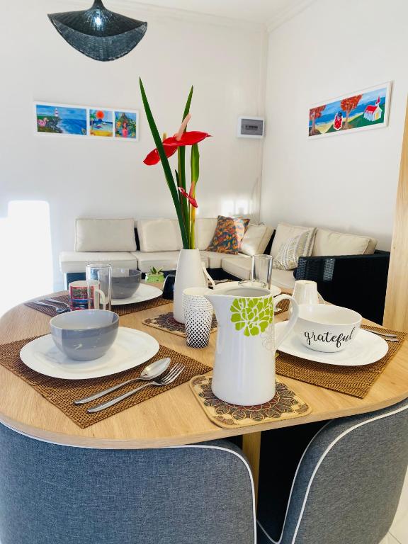 a dining room table with plates and vases on it at Cozy Corner 1 in Flic-en-Flac