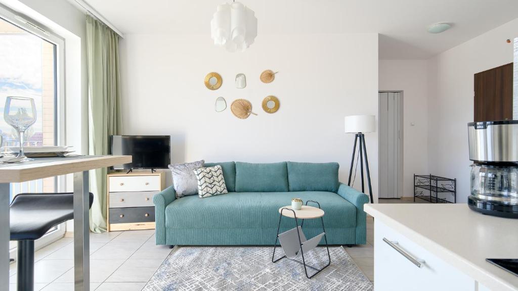 a living room with a blue couch in a kitchen at Apartament nad morzem in Kołobrzeg