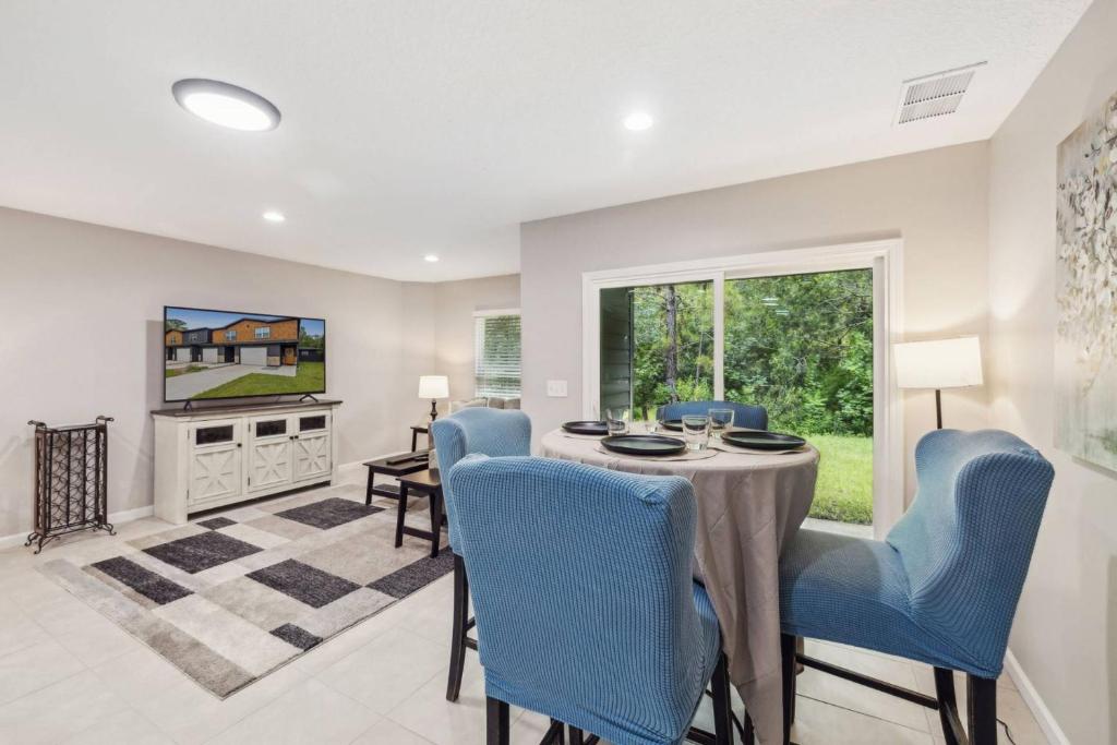 a dining room with a table and blue chairs at Isabella Ct Townhome in Orange Park