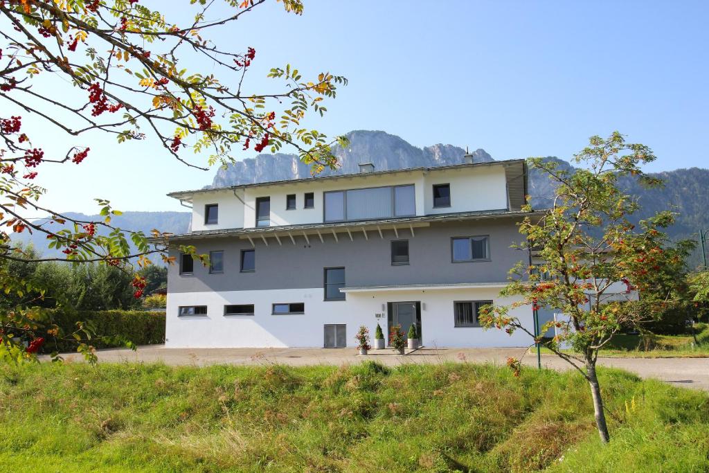 a large white building with a mountain in the background at Lorenzhaus Exclusive Residence in Sankt Lorenz