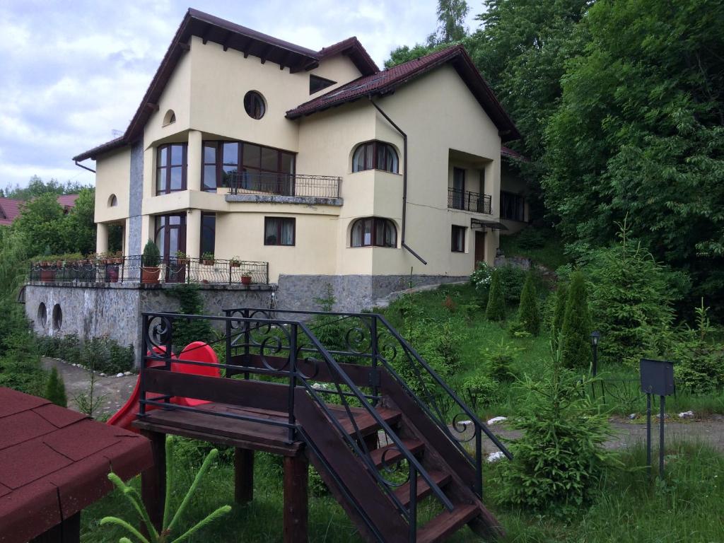 a house with a staircase in front of it at Pensiunea Ego in Bran