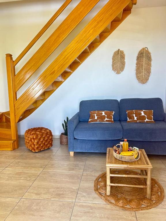 a living room with a blue couch and a table at Gîte Belle Place in Le Gosier