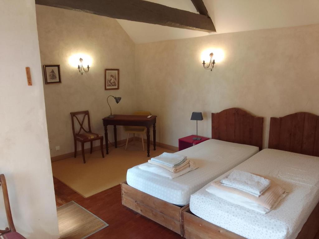 una camera con 2 letti singoli e un tavolo di La bourguignonne a Villemanoche