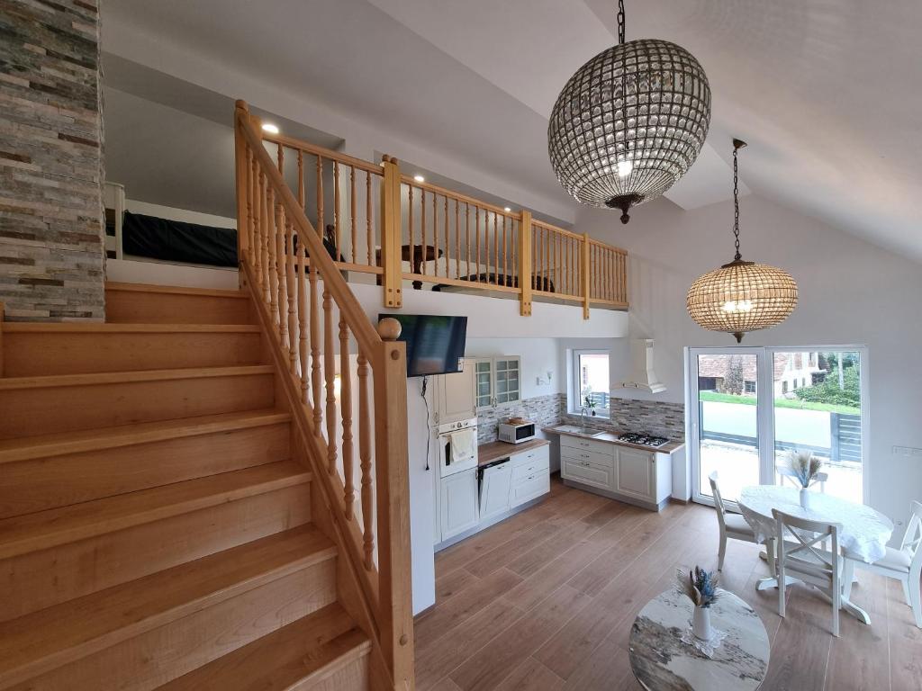 a staircase in a living room with a table and a kitchen at Domačija Rajsko srce in Šentjur