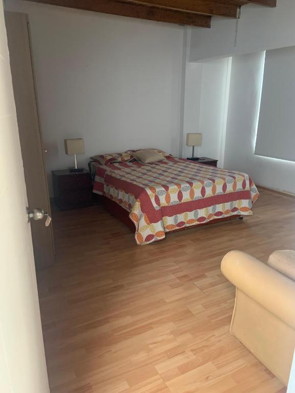 a bedroom with a bed and a wooden floor at Casa Ruiz Ganoza in San Antonio