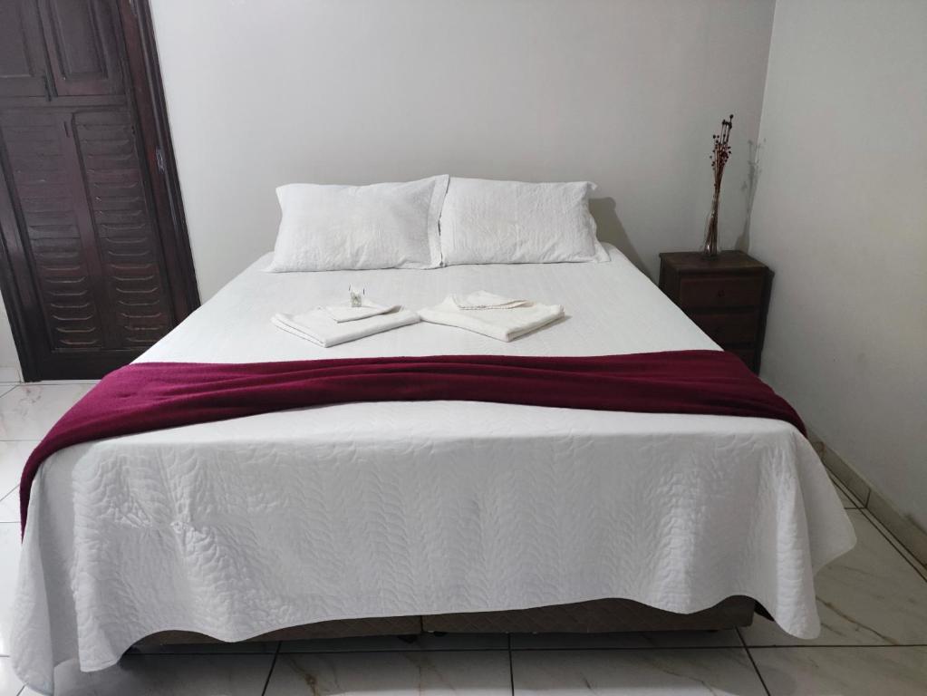 a bed with two white towels on top of it at Pousada Sinhá Moça in Diamantina