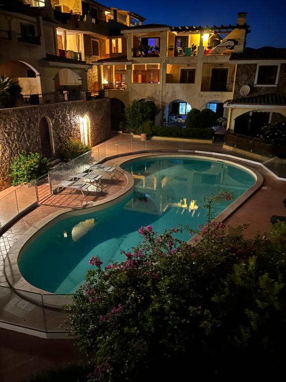 a large swimming pool in front of a building at night at Casa Bella Vista in Villasimius