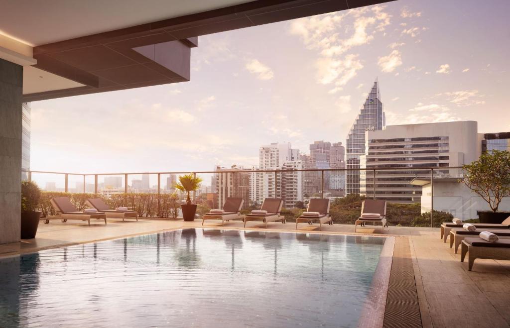 A rooftop pool overlooking Bangkok’s skyline in warm evening light.