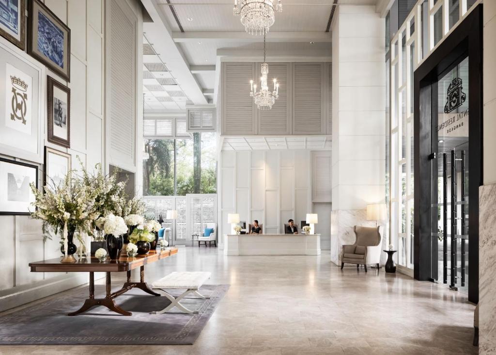 A bright formal reception hall with a flower display and visible front desk.