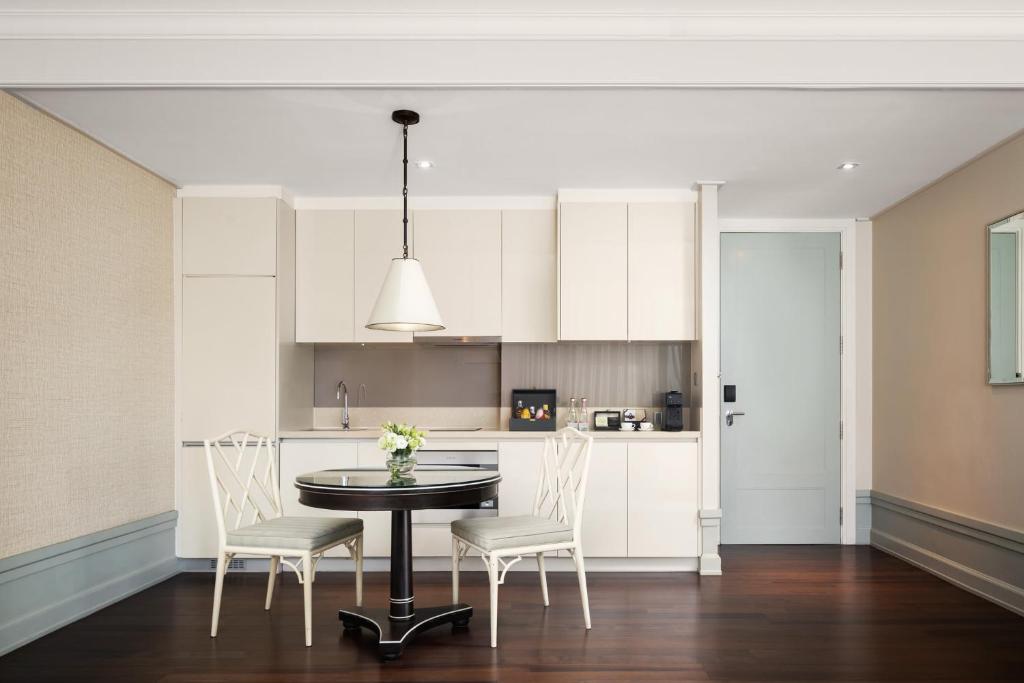 A compact fitted kitchen and dining nook with seating for two.