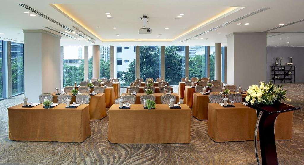A large, windowed meeting room arranged in classroom style with covered tables and a ceiling projector.