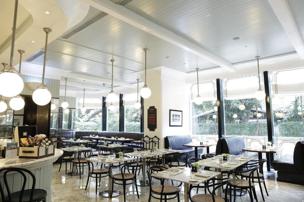 A bright dining room with window-side seating and closely spaced tables.