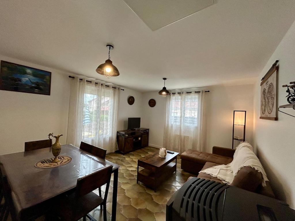 ein Wohnzimmer mit Sofa und Tisch in der Unterkunft Maison calme avec jardin & terrasses 