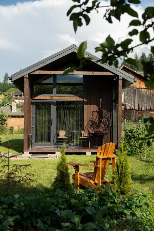 a small cabin with a bench in a yard at Bliss Cottage in Slavske