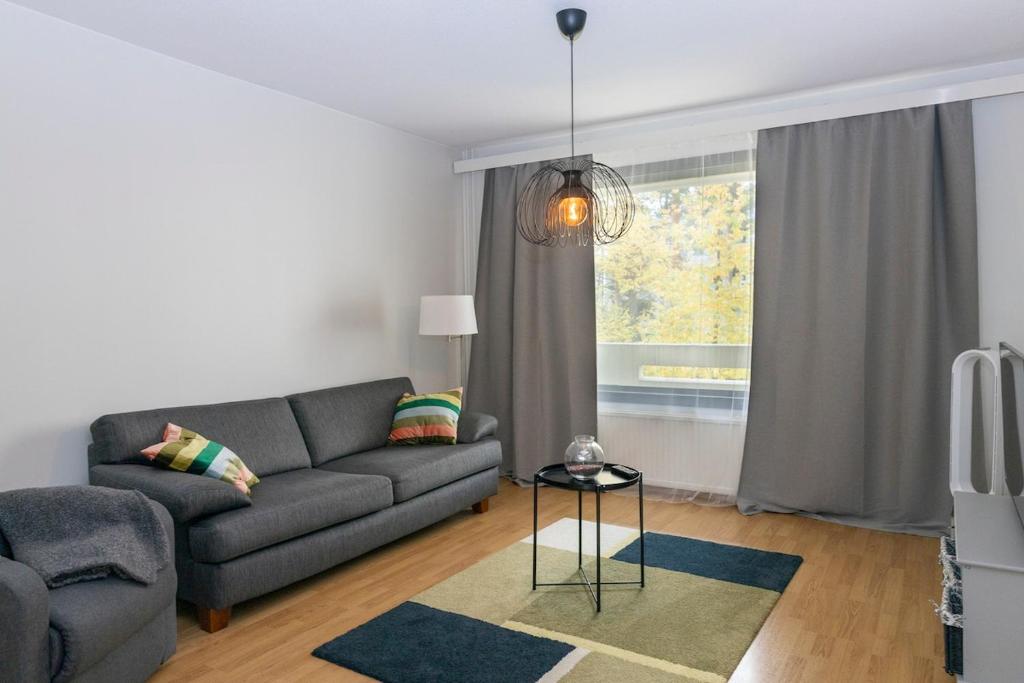 a living room with a couch and a table at One-bedroom apartment with free parking in Oulu