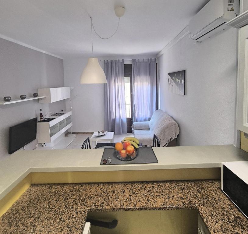 cocina y sala de estar con un plato de fruta en una mesa en Rincón en el centro de Palamós, en Palamós