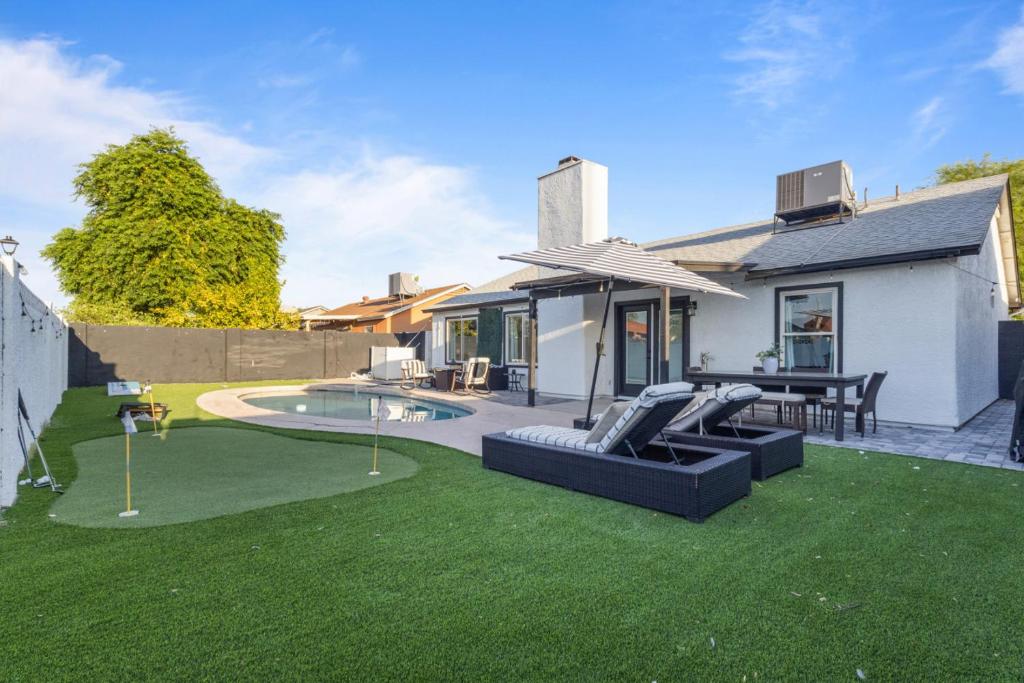 a backyard with a pool and a house with a lawn at Stadium Retreat 3Br Pool, Games, Relaxing Oasis in Glendale